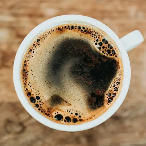 Long black coffee in a white cup, viewed from above